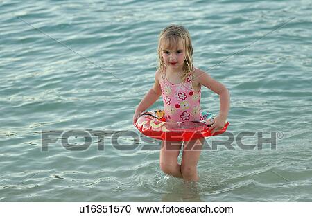 Close-up of a young girl wearing a rubber tube in water, Moorea, Tahiti, French Polynesia, South Pacific View Large Photo Image Stock Image - Close-up of a young girl wearing a rubber tube in water, Moorea, Tahiti, French Polynesia, South Pacific. Fotosearch