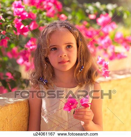 Close up of young girl holding pink flowers View Large Photo Image Stock Photo - Close up of young girl holding pink flowers. Fotosearch