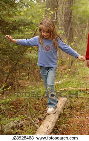 Stock Photo - Girl balancing on a log. Fotosearch