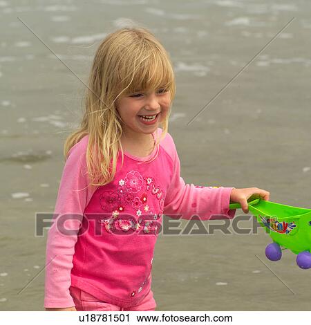 Stock Image - Girl standing in water on beach, Pacific Rim Park, Vancouver Island, Canada. Fotosearch