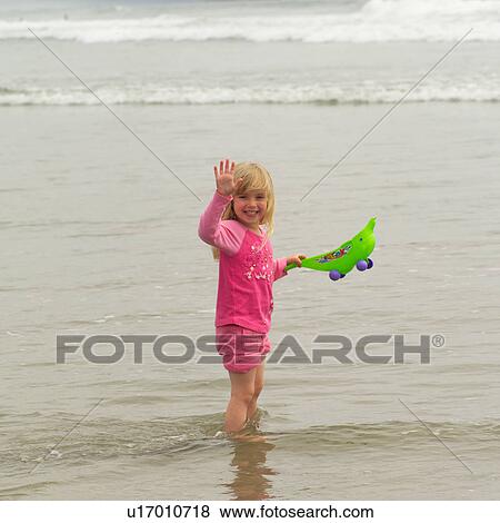Stock Photo - Girl standing in water on beach, Pacific Rim Park, Vancouver Island, Canada. Fotosearch