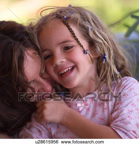 Stock Photograph - Mother cuddling with her daugher. Fotosearch