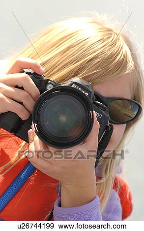 Portrait of a young girl using a camera View Large Photo Image Stock Photo - Portrait of a young girl using a camera. Fotosearch