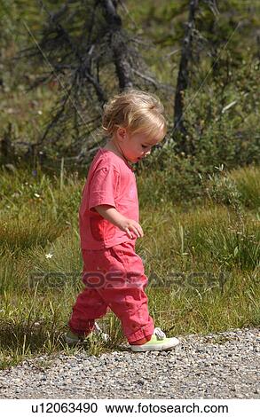 Stock Image - Young girl (2-4) walking in a forest, Rocky Mountains, Canada. Fotosearch