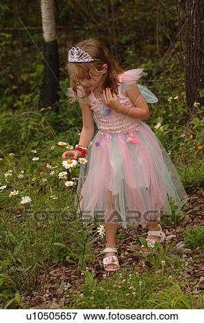 Stock Photo - Young girl in fairy costume picking wildflowers. Fotosearch