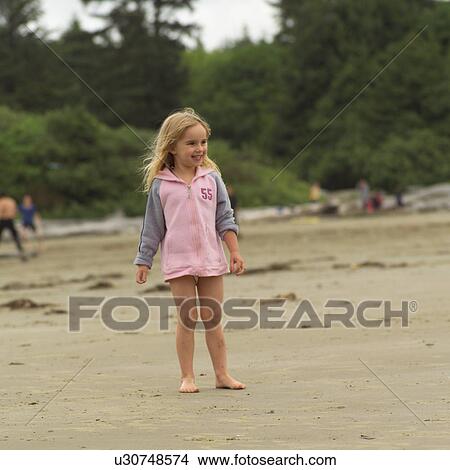 Picture - Young girl standing on beach, Pacific Rim Park, Vancouver Island, Canada. Fotosearch