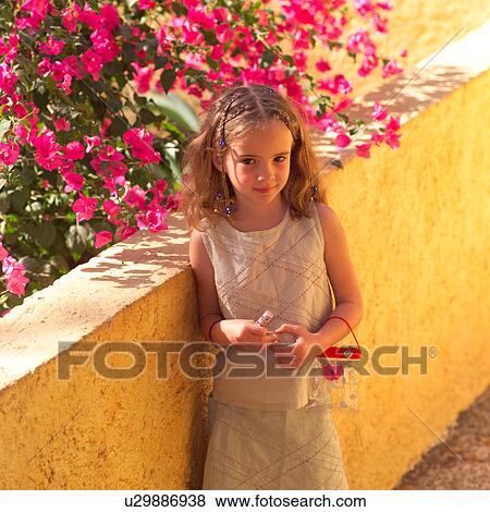 Young girl with flowers in background View Large Photo Image Stock Photo - Young girl with flowers in background. Fotosearch