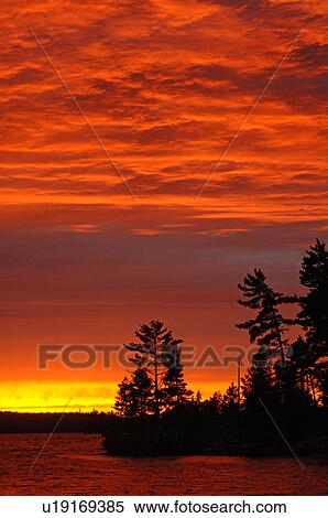 Stock Photography - Crimson sky over Lake of the Woods. Fotosearch