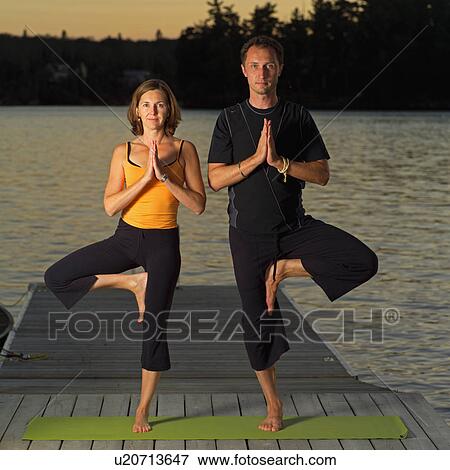 Stock Photo - Adult male and female doing yoga. Fotosearch