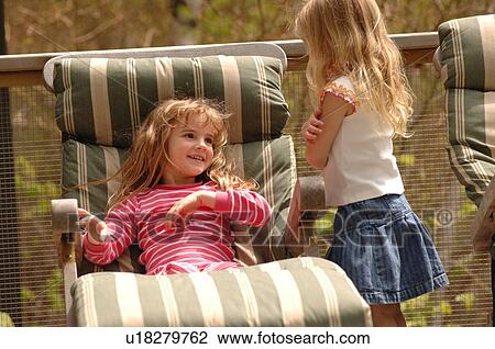 Stock Image - Child sitting in lounge chair. Fotosearch