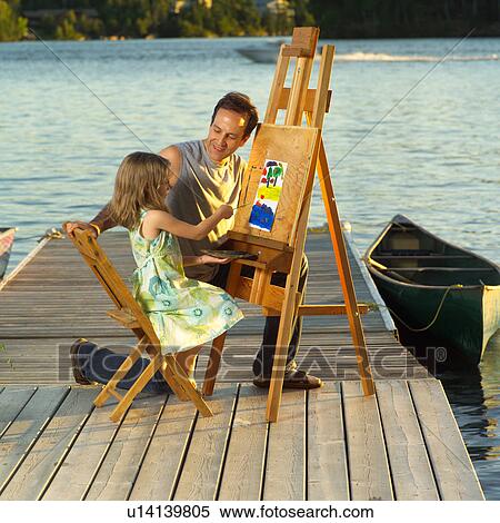Stock Photography - Girl painting while father watches. Fotosearch