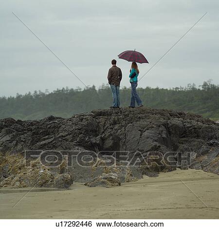 People standing on rocks at the seashore View Large Photo Image Stock Photograph - People standing on rocks at the seashore. Fotosearch