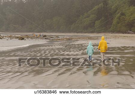 People walking on beach on a cloudy day View Large Photo Image Stock Photograph - People walking on beach on a cloudy day. Fotosearch