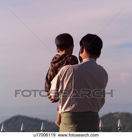 Stock Photo - Rear view of a man holding a child at Gold Rock. Fotosearch