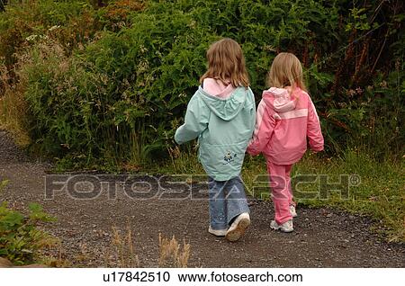 Stock Image - Two children walking along path in forest. Fotosearch