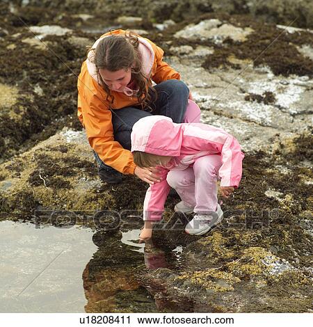 Stock Image - Two girls at the shoreline. Fotosearch