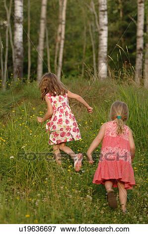 Stock Photo - Two girls running through grass. Fotosearch