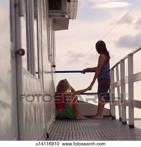 Two people holding hands while standing a boat deck View Large Photo Image Stock Image - Two people holding hands while standing a boat deck. Fotosearch