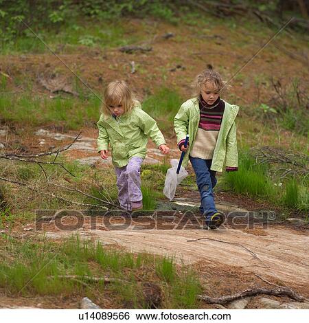 Two young girls walking in the woods with a butterfly net View Large Photo Image Stock Photograph - Two young girls walking in the woods with a butterfly net. Fotosearch