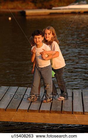 Stock Image - Young girl embracing a young boy. Fotosearch