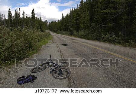 Stock Photo - A bicycle lying on the side of a country road. Fotosearch