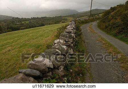 Stone fence along roadway View Large Photo Image Stock Photo - Stone fence along roadway. Fotosearch