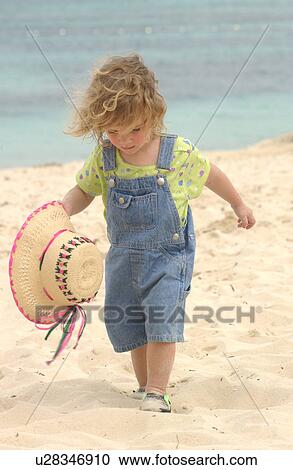 Stock Image - Child walking on beach. Fotosearch