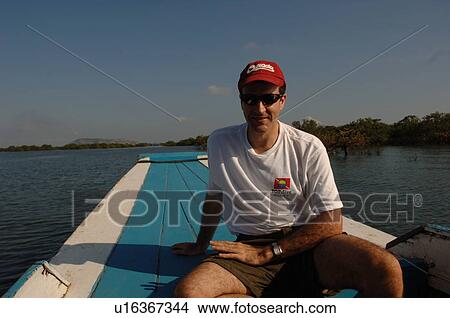 Male tourist riding on a boat View Large Photo Image Picture - Male tourist riding on a boat. Fotosearch