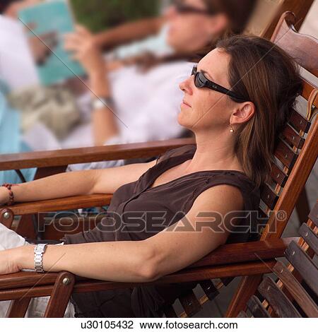 Stock Image - Profile of brunette woman wearing sunglasses. Fotosearch