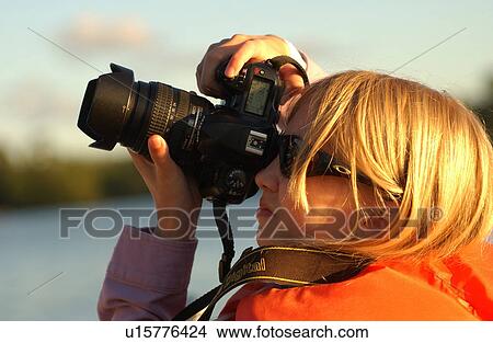Side profile of a young girl using a camera View Large Photo Image Picture - Side profile of a young girl using a camera. Fotosearch