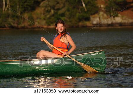 Teenager rowing a canoe View Large Photo Image Stock Photo - Teenager rowing a canoe. Fotosearch