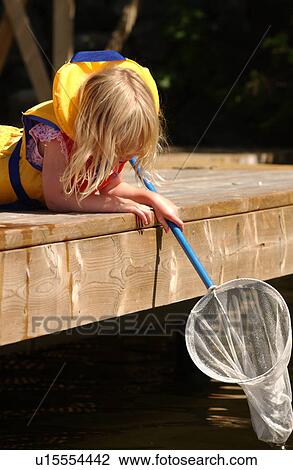 Young girl lying on a wooden platform holding a net View Large Photo Image Stock Image - Young girl lying on a wooden platform holding a net. Fotosearch