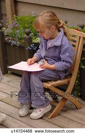 Young girl sitting in a chair drawing View Large Photo Image Stock Photo - Young girl sitting in a chair drawing. Fotosearch