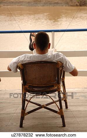 Back view of a man sitting in a chair View Large Photo Image Stock Image - Back view of a man sitting in a chair. Fotosearch