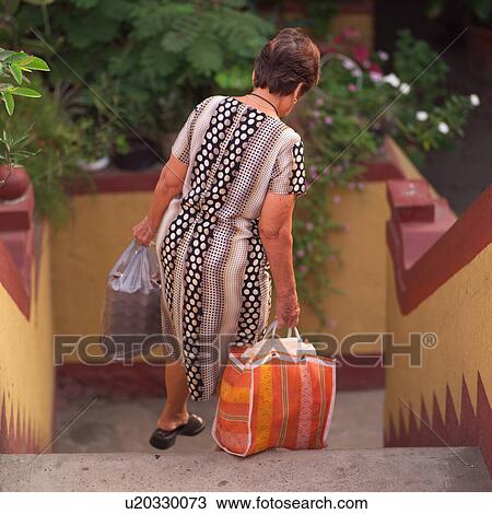Back view of a woman walking down staircase View Large Photo Image Stock Image - Back view of a woman walking down staircase. Fotosearch