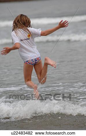 Stock Image - Girl running through water. Fotosearch