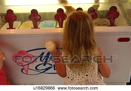 Stock Photograph - Rear of a young girl (10-12) looking into an ice cream freezer, Papeete, Tahiti. Fotosearch