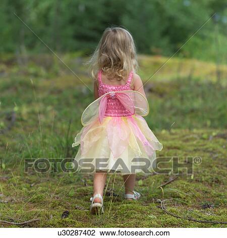 Rear view of a young girl in a fairy costume walking in the wilderness View Large Photo Image Stock Image - Rear view of a young girl in a fairy costume walking in the wilderness. Fotosearch