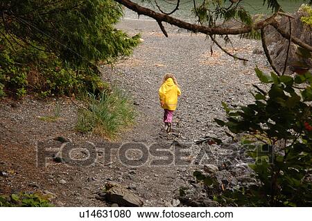 Stock Image - Small child walking along path in forest. Fotosearch