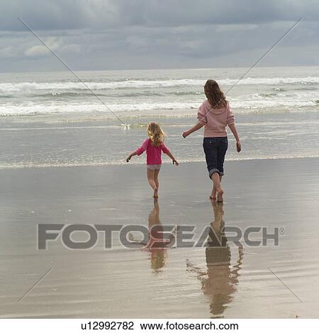 Two girls running towards ocean View Large Photo Image Stock Image - Two girls running towards ocean. Fotosearch