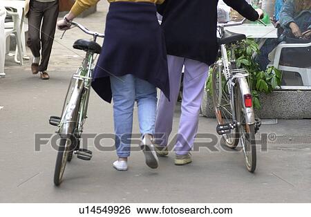 Two Women with Bikes View Large Photo Image Stock Photograph - Two Women with Bikes. Fotosearch
