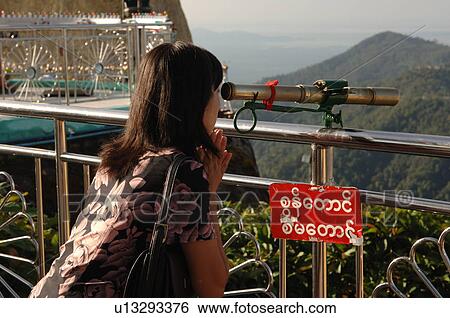 Woman looking through telescope at Golden Rock View Large Photo Image Stock Photograph - Woman looking through telescope at Golden Rock. Fotosearch