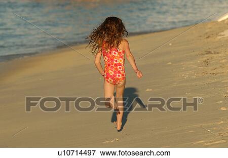 Young girl running on a beach View Large Photo Image Stock Photo - Young girl running on a beach. Fotosearch