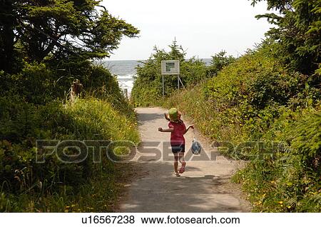 Young girl walking along path in forest View Large Photo Image Stock Photo - Young girl walking along path in forest. Fotosearch