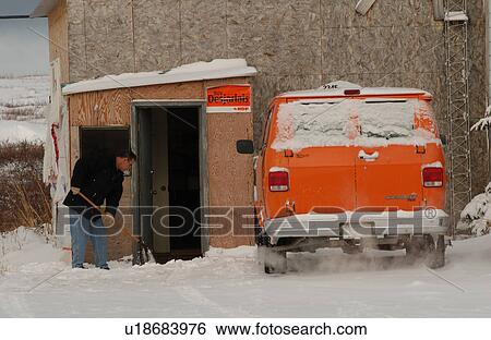 Stock Photograph - Churchill Northern Manitoba town and surroundings Man shovelling snow. Fotosearch