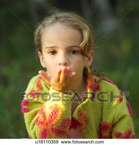 Stock Photo - 5 - 6 year old blowing into her hand. Fotosearch