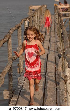 5 year old girl running on wooden pier View Large Photo Image Stock Photo - 5 year old girl running on wooden pier. Fotosearch