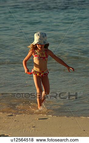 A young girl playing on a beach View Large Photo Image Stock Photo - A young girl playing on a beach. Fotosearch