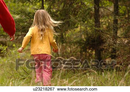 Stock Photo - Blonde child running through field of grass. Fotosearch