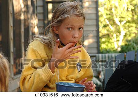 Stock Photograph - Girl licking her fingers. Fotosearch
